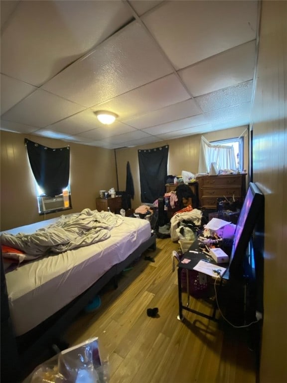 bedroom with a paneled ceiling and hardwood / wood-style floors