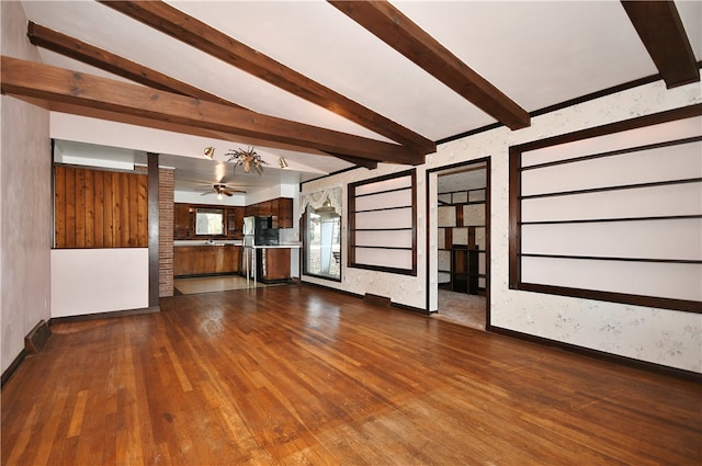 unfurnished living room featuring wood-type flooring, vaulted ceiling with beams, and ceiling fan