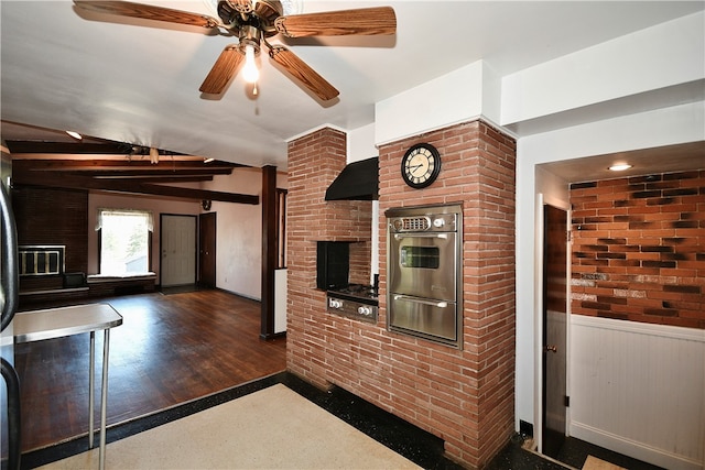 kitchen with dark wood-type flooring, oven, vaulted ceiling, ceiling fan, and brick wall