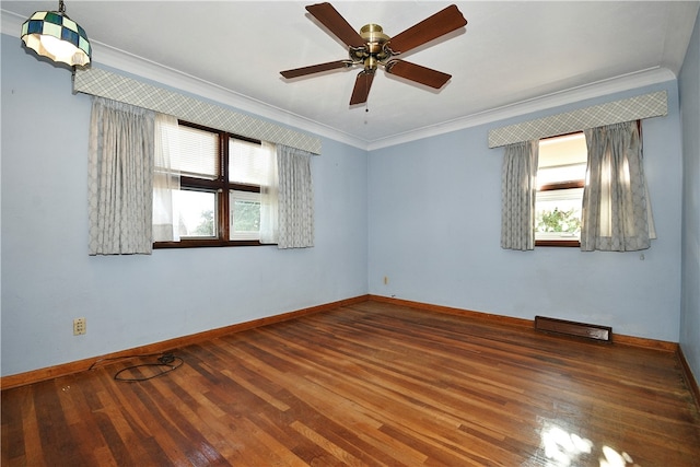 empty room with hardwood / wood-style flooring, ceiling fan, and crown molding