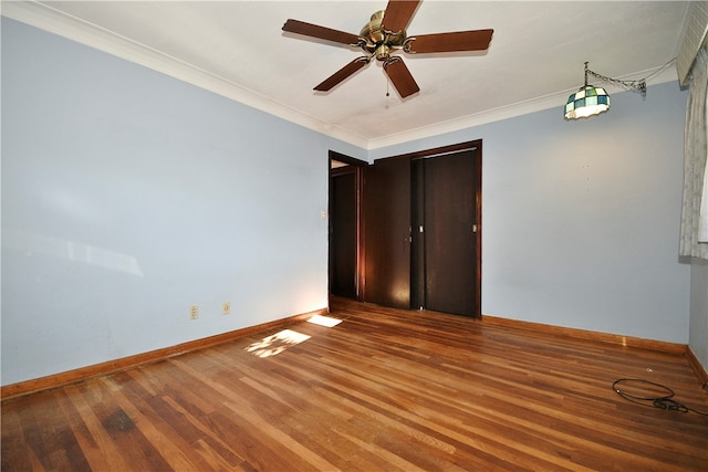 unfurnished bedroom featuring hardwood / wood-style floors, a closet, ceiling fan, and ornamental molding