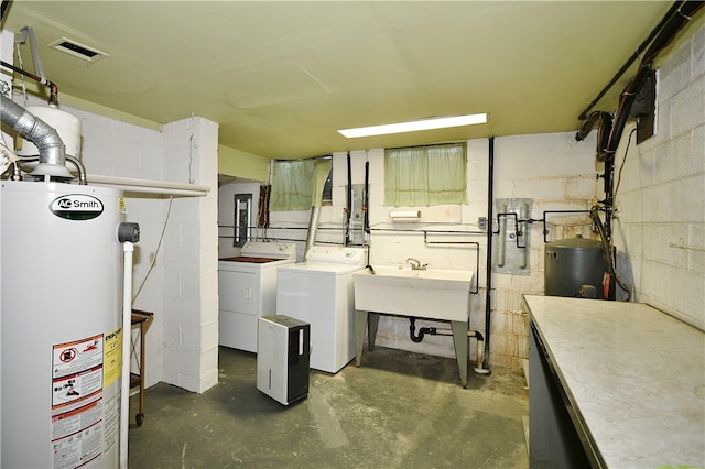 interior space featuring sink, washer and clothes dryer, and water heater