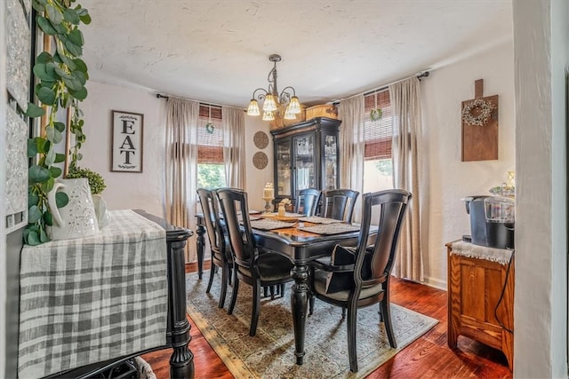 dining area featuring dark hardwood / wood-style floors, plenty of natural light, and a notable chandelier