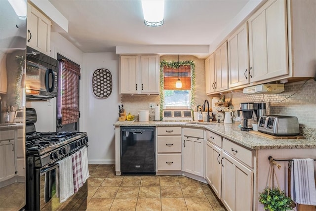 kitchen featuring decorative backsplash, sink, light stone counters, and black appliances