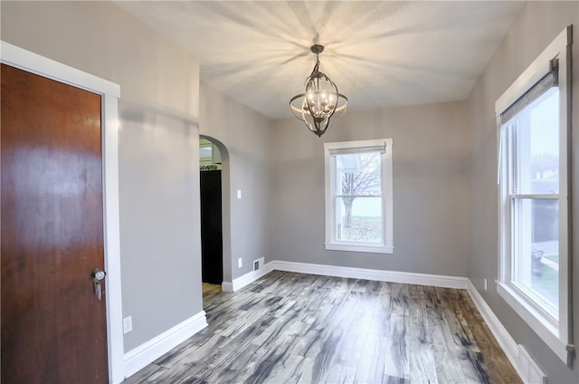 unfurnished room featuring a chandelier and hardwood / wood-style flooring