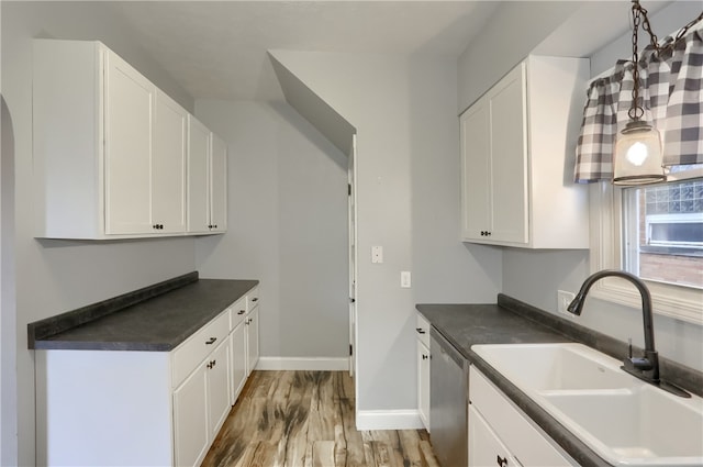 kitchen with white cabinetry, sink, stainless steel dishwasher, and light hardwood / wood-style flooring