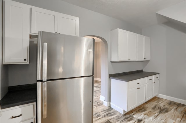 kitchen featuring white cabinets, light hardwood / wood-style flooring, and stainless steel refrigerator