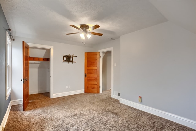 unfurnished bedroom featuring carpet, a textured ceiling, a closet, and ceiling fan