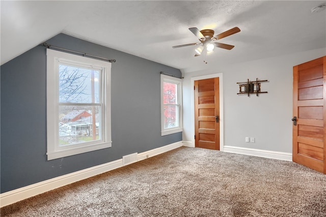 unfurnished bedroom featuring ceiling fan, carpet, and lofted ceiling