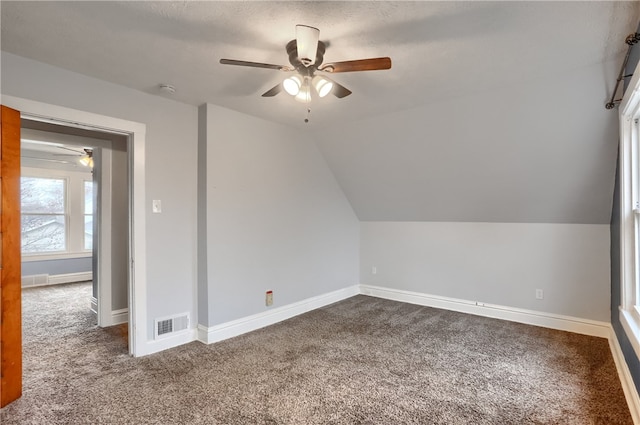 additional living space featuring carpet, ceiling fan, lofted ceiling, and a textured ceiling