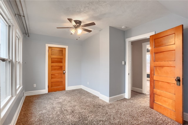 carpeted empty room with a textured ceiling and ceiling fan