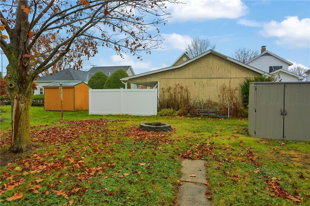 view of yard featuring a fire pit and a storage unit