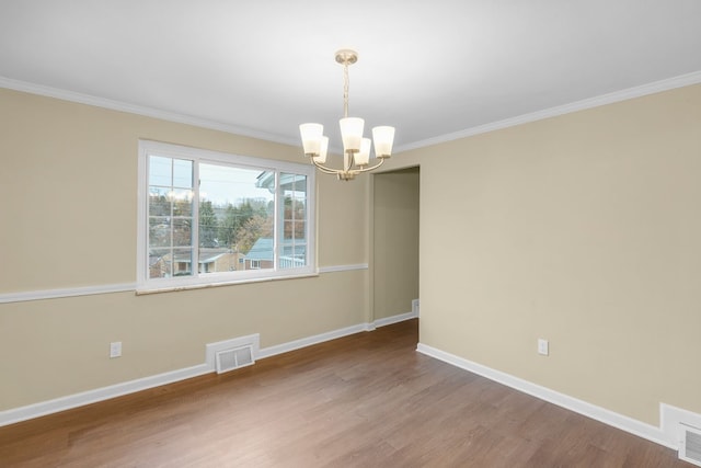 unfurnished room featuring ornamental molding, a notable chandelier, and hardwood / wood-style flooring