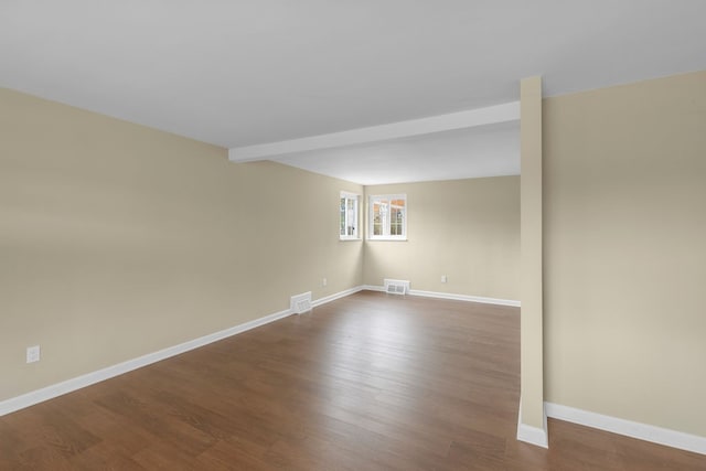 spare room with beam ceiling and hardwood / wood-style floors