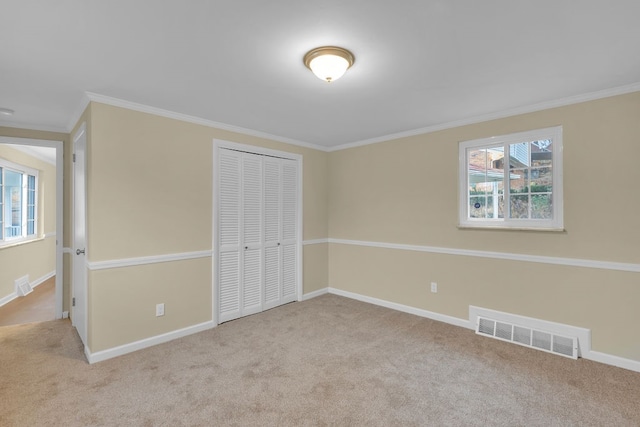 unfurnished bedroom with ornamental molding, light carpet, and a closet