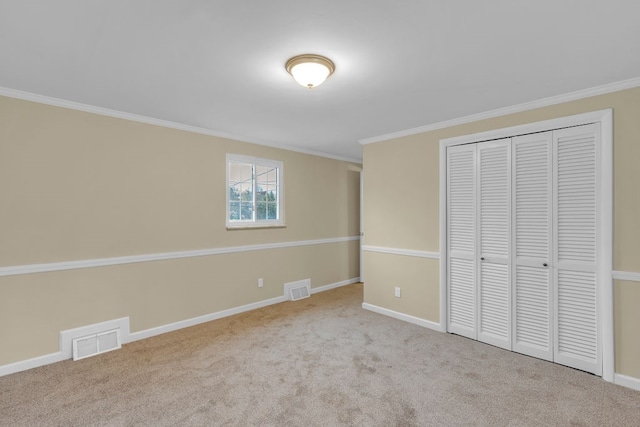 unfurnished bedroom with a closet, light carpet, and crown molding