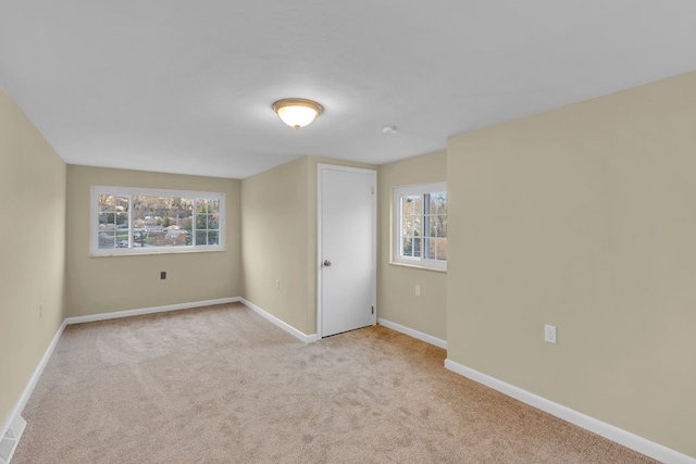 unfurnished room with a healthy amount of sunlight and light colored carpet