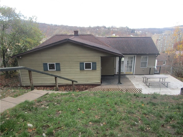 back of house with a lawn and a patio area