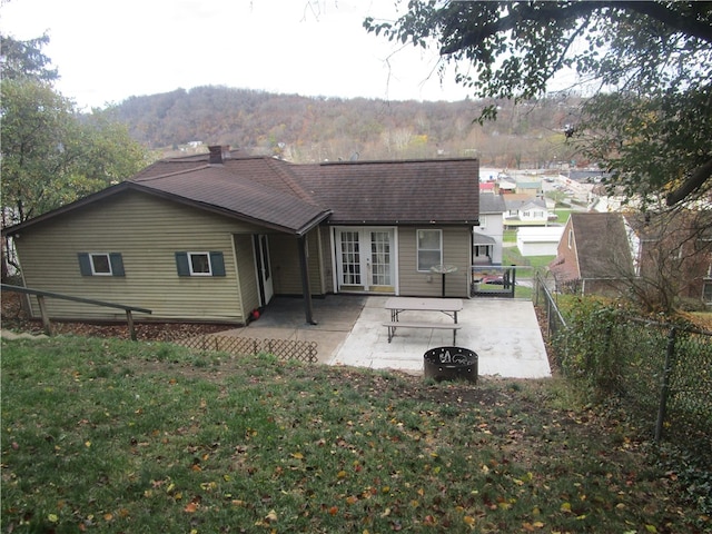 back of house with a patio area, a yard, an outdoor fire pit, and french doors