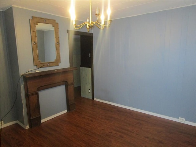 unfurnished room with an inviting chandelier, dark wood-type flooring, and crown molding