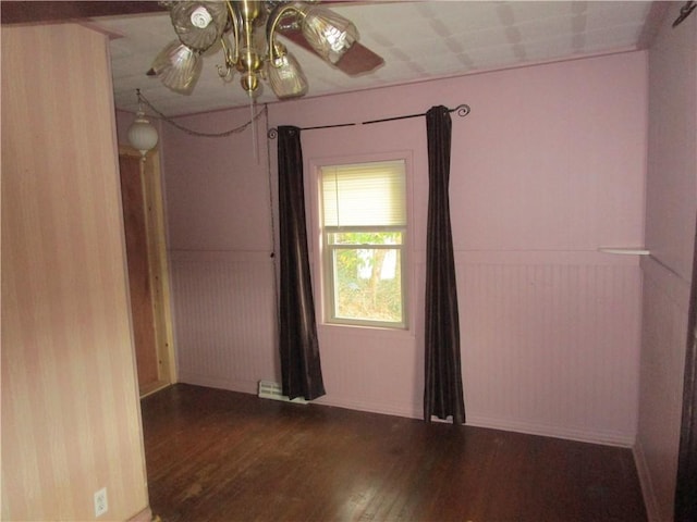 spare room with ceiling fan, hardwood / wood-style floors, and wood walls