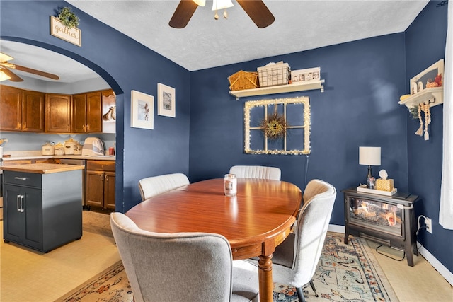 dining space featuring ceiling fan and a textured ceiling