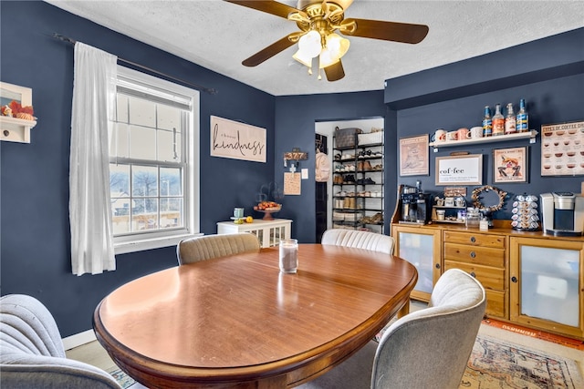 dining room featuring ceiling fan and a textured ceiling