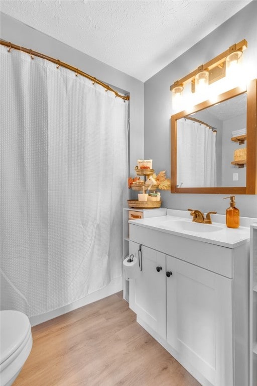 bathroom featuring hardwood / wood-style floors, vanity, and a textured ceiling