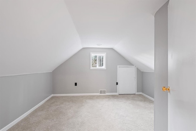 additional living space featuring carpet flooring and lofted ceiling