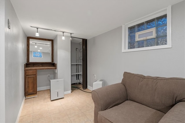 living room featuring light tile patterned flooring, built in desk, and track lighting