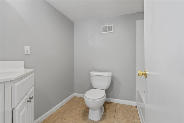 bathroom with tile patterned floors, a tub, vanity, and toilet