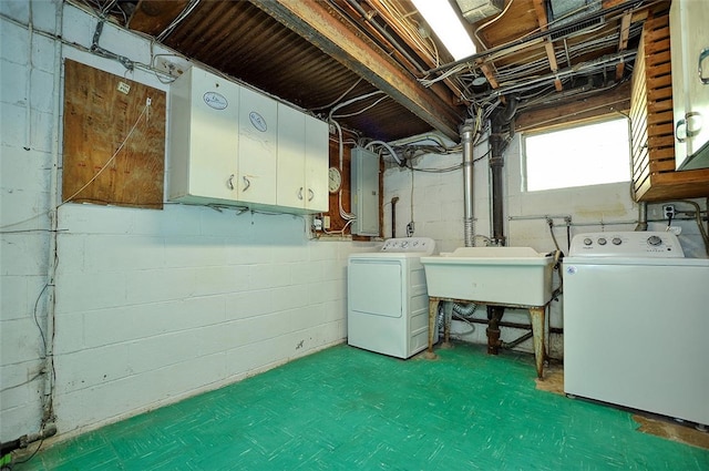 laundry area with separate washer and dryer, electric panel, cabinets, and sink