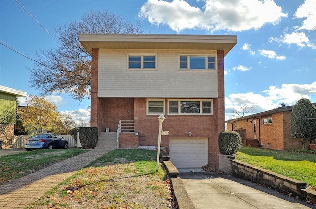 view of property featuring a garage and a front lawn