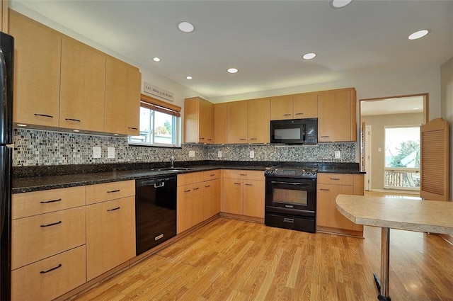 kitchen featuring sink, backsplash, light brown cabinetry, black appliances, and light wood-type flooring