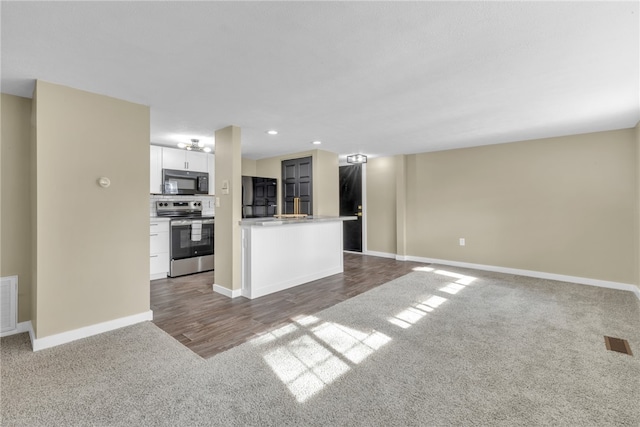 kitchen with white cabinets, black appliances, and wood-type flooring