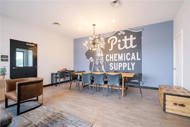 dining space with a notable chandelier and hardwood / wood-style flooring