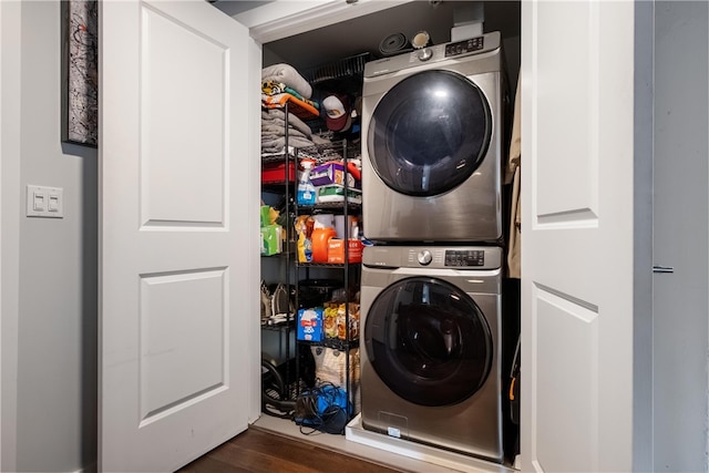 clothes washing area with dark hardwood / wood-style flooring and stacked washer and dryer