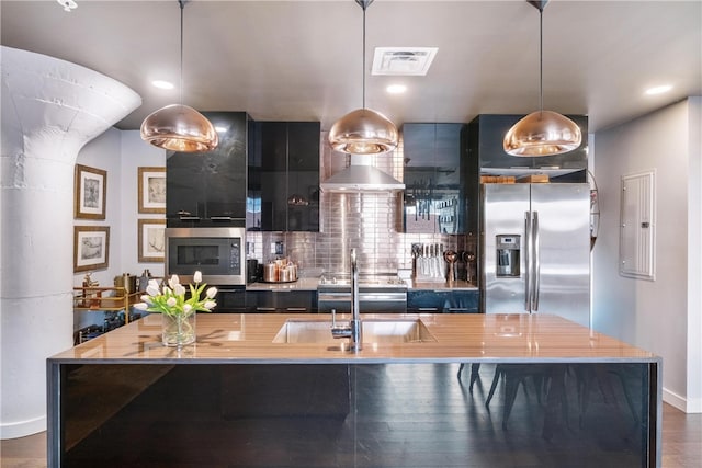 kitchen featuring appliances with stainless steel finishes, dark hardwood / wood-style floors, pendant lighting, and sink