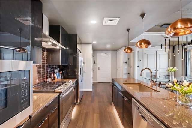 kitchen featuring sink, hanging light fixtures, stainless steel appliances, dark hardwood / wood-style floors, and decorative backsplash