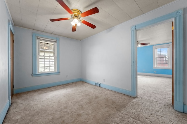 carpeted empty room featuring ceiling fan and crown molding