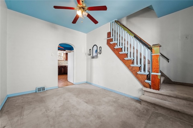 unfurnished living room featuring ceiling fan and carpet floors