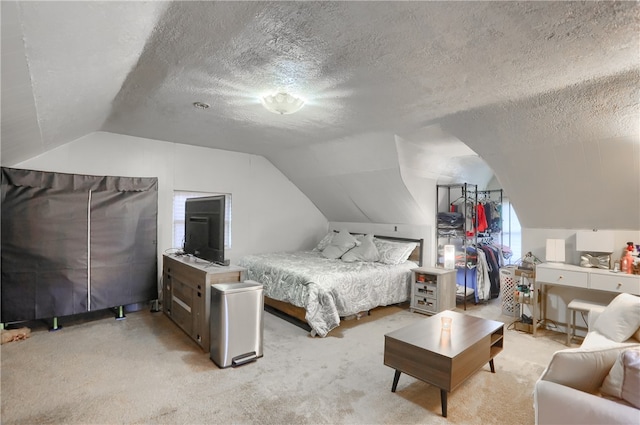 carpeted bedroom with a textured ceiling and lofted ceiling