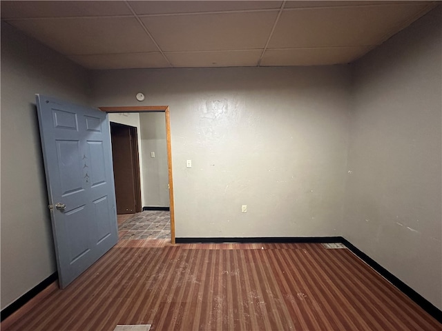 unfurnished room featuring hardwood / wood-style flooring and a drop ceiling