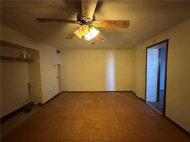 empty room featuring ceiling fan and parquet flooring