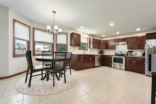 kitchen with hanging light fixtures, stainless steel appliances, a wealth of natural light, and a chandelier