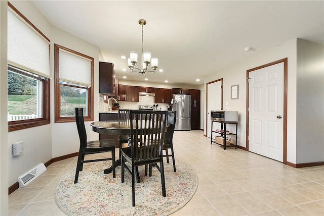 tiled dining room with sink and a chandelier