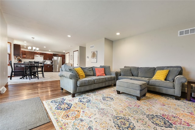 living room featuring light hardwood / wood-style floors and a notable chandelier