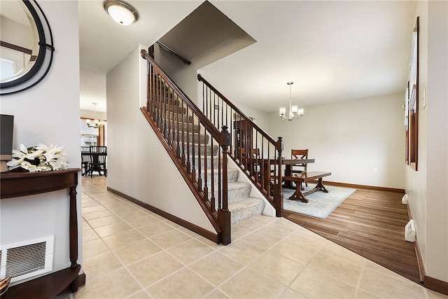 stairway with a chandelier and hardwood / wood-style floors