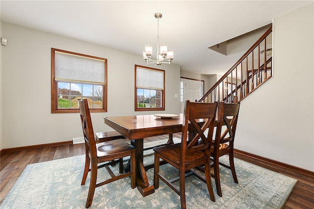 dining space featuring a notable chandelier and dark wood-type flooring