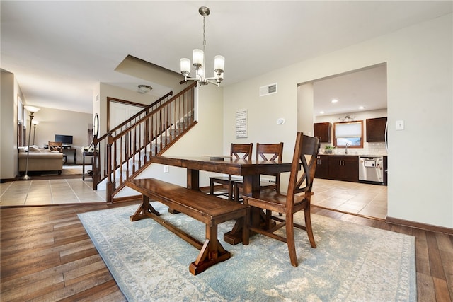 dining space featuring a notable chandelier, light wood-type flooring, and sink